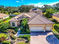 Tan two-story house with a three-car garage, landscaping, and solar panels at 4679 Tuscana Dr, Sarasota, FL 34241