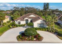 Beautiful single-story home featuring a tile roof, circular driveway, and lush landscaping at 5245 88Th E St, Bradenton, FL 34211