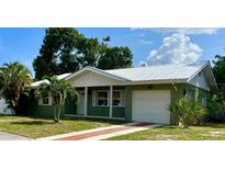 Green house with white trim, brick walkway, and attached garage at 615 49Th Street W Ct, Bradenton, FL 34209