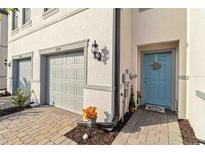 Townhouse exterior featuring a light-grey double garage and a teal front door at 6404 Silverstar Dr, Sarasota, FL 34240