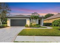 Single-story home with a gray garage door, landscaping, and a paved walkway at 10114 Glenmore Ave, Bradenton, FL 34202