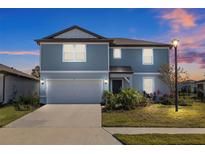 Two-story house with gray siding, attached garage, and landscaping at 11628 Middle Fork Way, Parrish, FL 34219