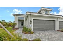 Single-story home with gray garage door and paved driveway at 12681 Palatka Dr, Venice, FL 34293