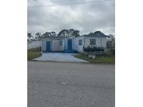 White single-wide manufactured home with blue trim and small yard at 1660 Old Elm St, Sarasota, FL 34234