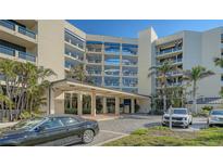 Condo building exterior featuring attractive landscaping and ample parking at 2110 Harbourside Dr # 522, Longboat Key, FL 34228