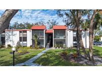 Two-story condo building with red tile roofs, screened balconies, and landscaping at 3259 Beneva Rd # 102, Sarasota, FL 34232