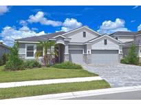 Two-story home with gray siding, stone accents, and a three-car garage at 4326 Silo Port Ct, Lakewood Ranch, FL 34211
