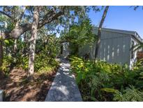Brick walkway leads to charming home entrance, surrounded by lush landscaping at 752 Tropical Cir, Sarasota, FL 34242