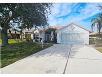 Single-story home with a tile roof, attached garage, and landscaped lawn at 8282 Parkside Dr, Englewood, FL 34224