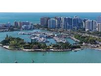 Aerial view of waterfront property, showcasing a luxury highrise building and marina at 1111 N Gulfstream Ave # 3E, Sarasota, FL 34236