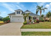 White one-story house with a two-car garage, landscaping, and palm trees at 12240 Whisper Lake Dr, Bradenton, FL 34211