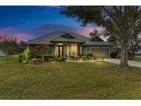 Well-maintained house with metal roof, landscaping, and a two-car garage at 304 147Th E St, Bradenton, FL 34212