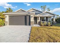 New construction home with a two-car garage and landscaped lawn at 1463 Jinright Rd, North Port, FL 34288