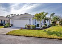 Single-story home with a two-car garage and lush landscaping at 1570 Monarch Dr, Venice, FL 34293