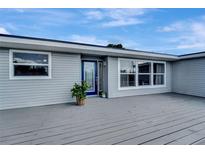 Gray house with a blue door and a large deck at 2726 Jerry Ave, Punta Gorda, FL 33950