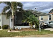 Mobile home with carport, golf cart, and landscaped yard at 322 Blackburn Blvd, North Port, FL 34287
