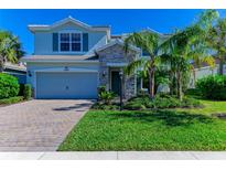 Two-story house with stone accents and a gray garage door at 3409 Anchor Bay Trl, Lakewood Ranch, FL 34211
