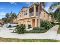 Tan two-story townhome with attached garage and lush landscaping at 3557 Parkridge Cir # 14-106, Sarasota, FL 34243