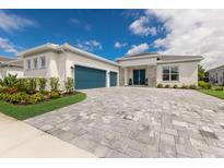 Two-story house with teal garage doors and a paved driveway at 4697 Antrim Dr, Sarasota, FL 34240