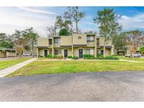 Tan colored two-story condo building with lush landscaping and a walkway at 4918 25Th W St # 102, Bradenton, FL 34207