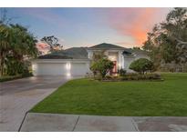 Beautiful home with lush landscaping, large lawn, and a paved driveway at 6702 Pinehurst Pl, Bradenton, FL 34202