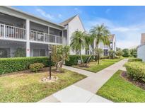 Condo building with walkway, landscaping, and palm trees at 6807 Stone River Rd # 204, Bradenton, FL 34203