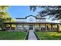 Two-story house with a large front porch, brick columns, and a landscaped lawn at 12001 Backwater Rd, Sarasota, FL 34240