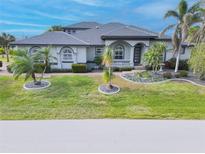 Two-story house with gray exterior and palm trees at 3607 Darin Dr, Punta Gorda, FL 33950