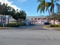 Pink condo building with carport and palm trees at 4220 Pinebrook Cir # 12, Bradenton, FL 34209