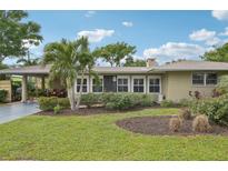 Tan single-story home with palm trees and manicured lawn at 430 Beach Park Blvd, Venice, FL 34285