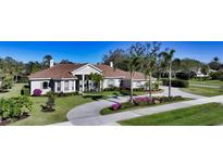 Single-story home with tile roof, palm trees, and landscaped yard at 7419 Albert Tillinghast Dr, Sarasota, FL 34240