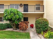 Ground-level condo entrance with lush landscaping and walkway at 7880 Palm Aire Ln # 103, Sarasota, FL 34243