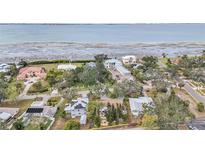 Aerial view of waterfront home with large lot and mature trees at 8135 Longbay Blvd, Sarasota, FL 34243