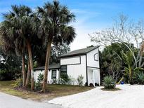 Charming white cottage with palm trees and a gravel driveway at 4211 Old Bradenton Rd, Sarasota, FL 34234