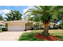 Single-story home with white garage door and palm tree landscaping at 5721 Garden Lakes Majestic, Bradenton, FL 34203