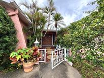 Inviting front entrance with lush landscaping and decorative gate at 1741 Font Ln, Holiday, FL 34691