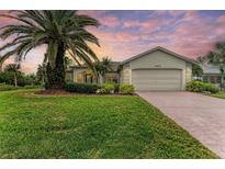 Beautiful home with a lush lawn and palm trees at 17413 Pheasant Cir, Port Charlotte, FL 33948