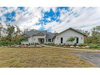 Craftsman style home with gray siding, landscaping, and a paved driveway at 3514 62Nd E St, Bradenton, FL 34208