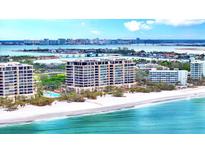 Beautiful waterfront condo building on the white sands of a beach with city views in the background at 415 L Ambiance Dr # A701, Longboat Key, FL 34228
