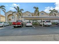 Exterior view of condo building with covered parking and landscaping at 4230 Castlebridge Ln # 1821, Sarasota, FL 34238