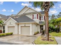 Two-story townhome with two-car garage, palm trees, and attractive landscaping at 7946 Tybee Ct, University Park, FL 34201