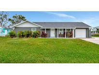 Gray house with white trim, landscaping, and a two-car garage at 905 69Th Nw St, Bradenton, FL 34209