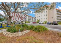 River Oaks condo complex, featuring building exterior, parking, and landscaping at 1600 1St W Ave # 304A, Bradenton, FL 34205