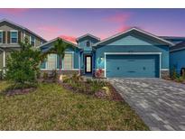 Two-story light blue house with a gray paved driveway and landscaping at 16257 S Port Harbor Blvd, Port Charlotte, FL 33953