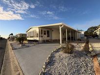 White single-wide manufactured home with carport and landscaped yard at 2107 Palma Sola Blvd # 42, Bradenton, FL 34209