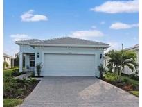 Newly constructed home with a two-car garage and landscaped front yard at 25532 Royal Tern Ln, Englewood, FL 34223