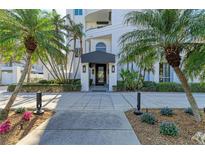 Modern building entrance with palm trees and walkway at 306 Golden Gate Pt # 2, Sarasota, FL 34236