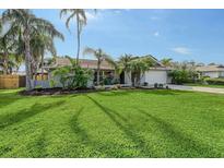 Single-story home with a lush lawn and mature palm trees at 6549 Waterford Cir, Sarasota, FL 34238