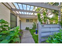 Inviting patio with pergola, lush landscaping, and a bird bath at 131 Pinehurst Dr # 131, Bradenton, FL 34210