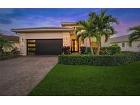 Attractive house exterior featuring a modern design, two-car garage, and landscaping at 4947 Surfside Cir, Bradenton, FL 34211
